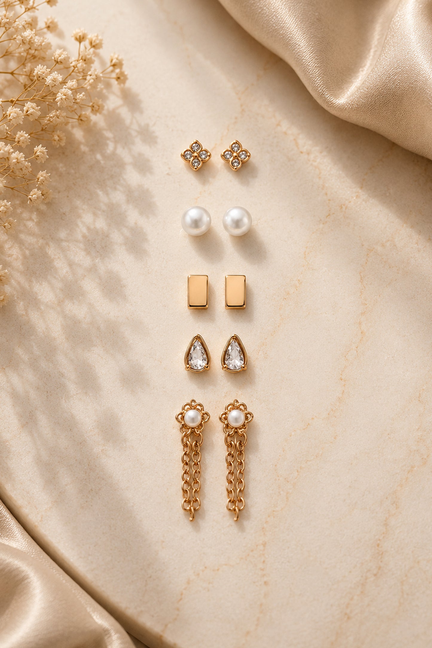 Gold-tone stud and hoop collection photographed in warm natural light