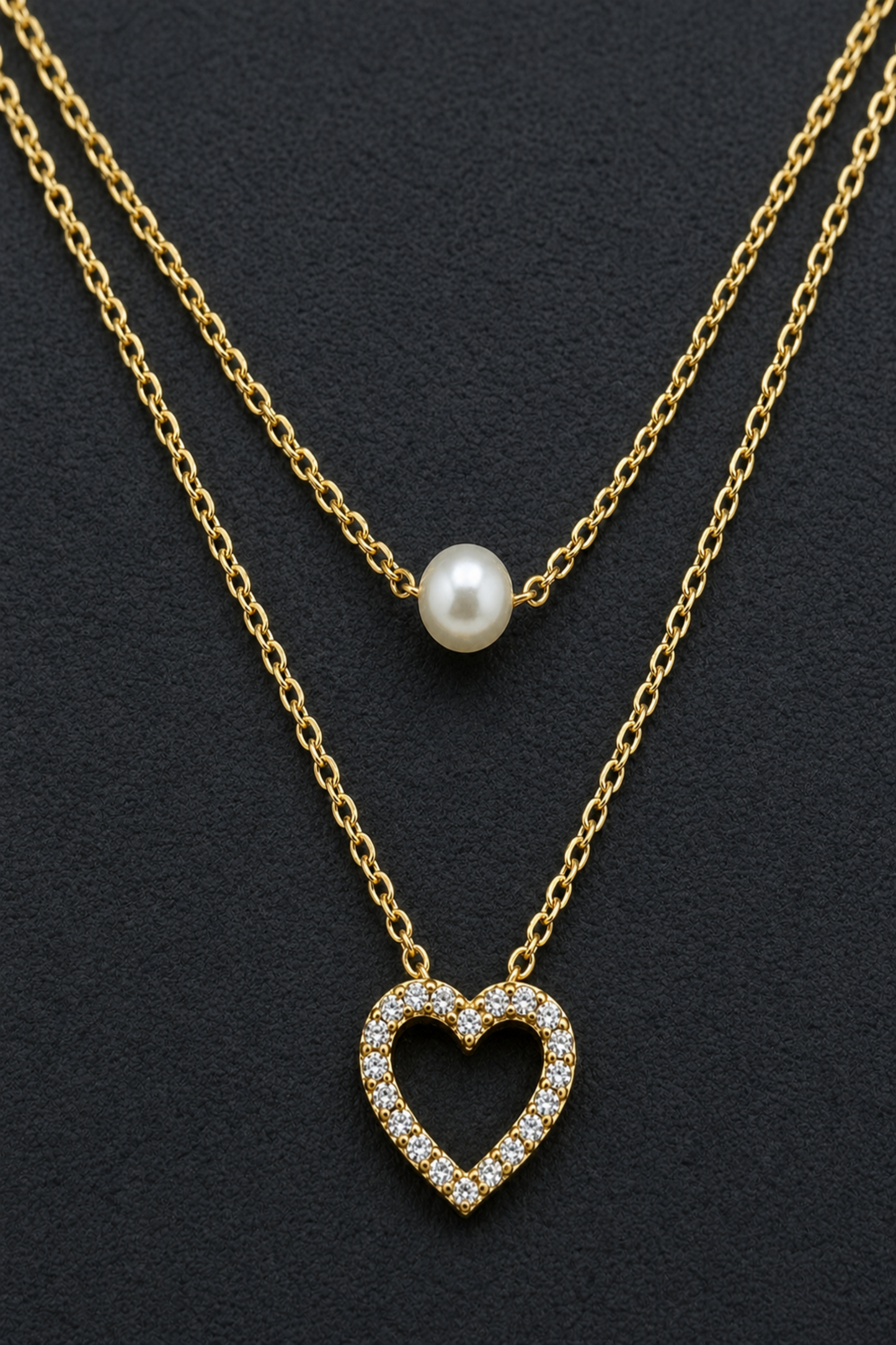 close up of pearl and heart layered necklace