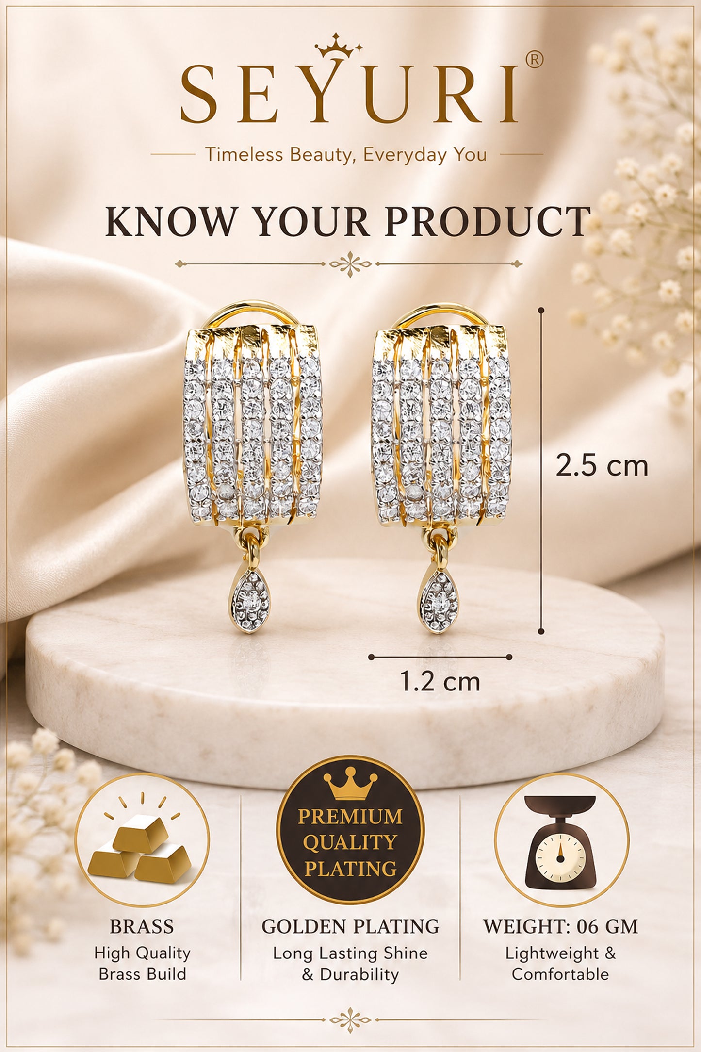 Gold plated earrings displayed on satin background