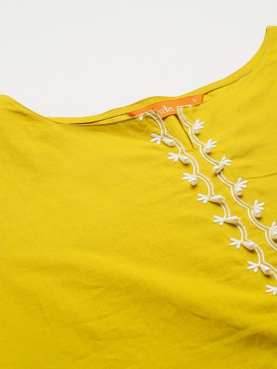 Yellow top with white embroidery on a light gray background