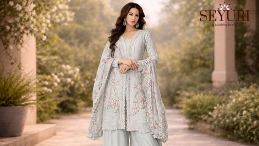 Mint green embroidered Pakistani palazzo suit with floral dupatta, styled in a sunlit garden setting, elegant wedding guest outfit for women in USA