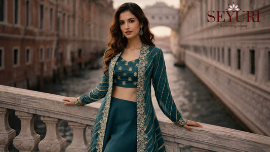Elegant woman wearing a green designer ethnic outfit with gold embroidery, standing on a historic bridge in a European city, showcasing festive and wedding fashion inspiration.