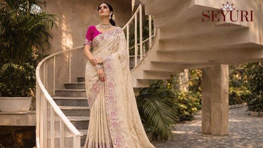 Luxury saree fashion shoot on spiral staircase with modern architectural background and natural sunlight.