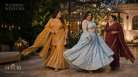 Plus size Indian wedding guest outfits featuring a yellow sharara, blue lehenga and wine saree at an evening venue.