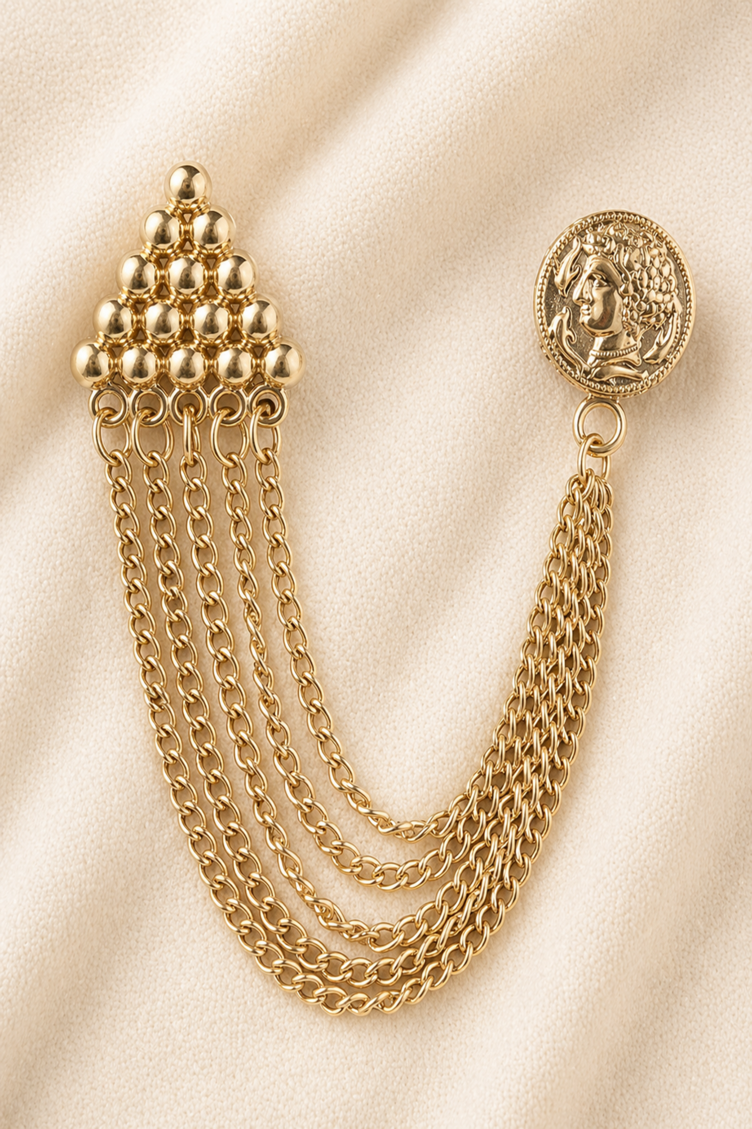 gold chain brooch with layered chains on fabric