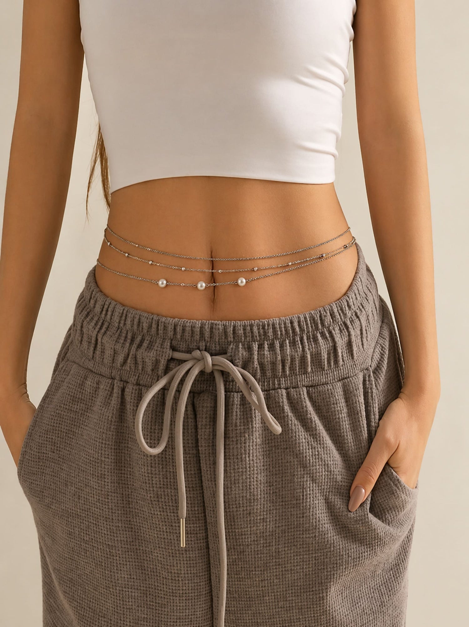 model wearing layered waist chain over pants