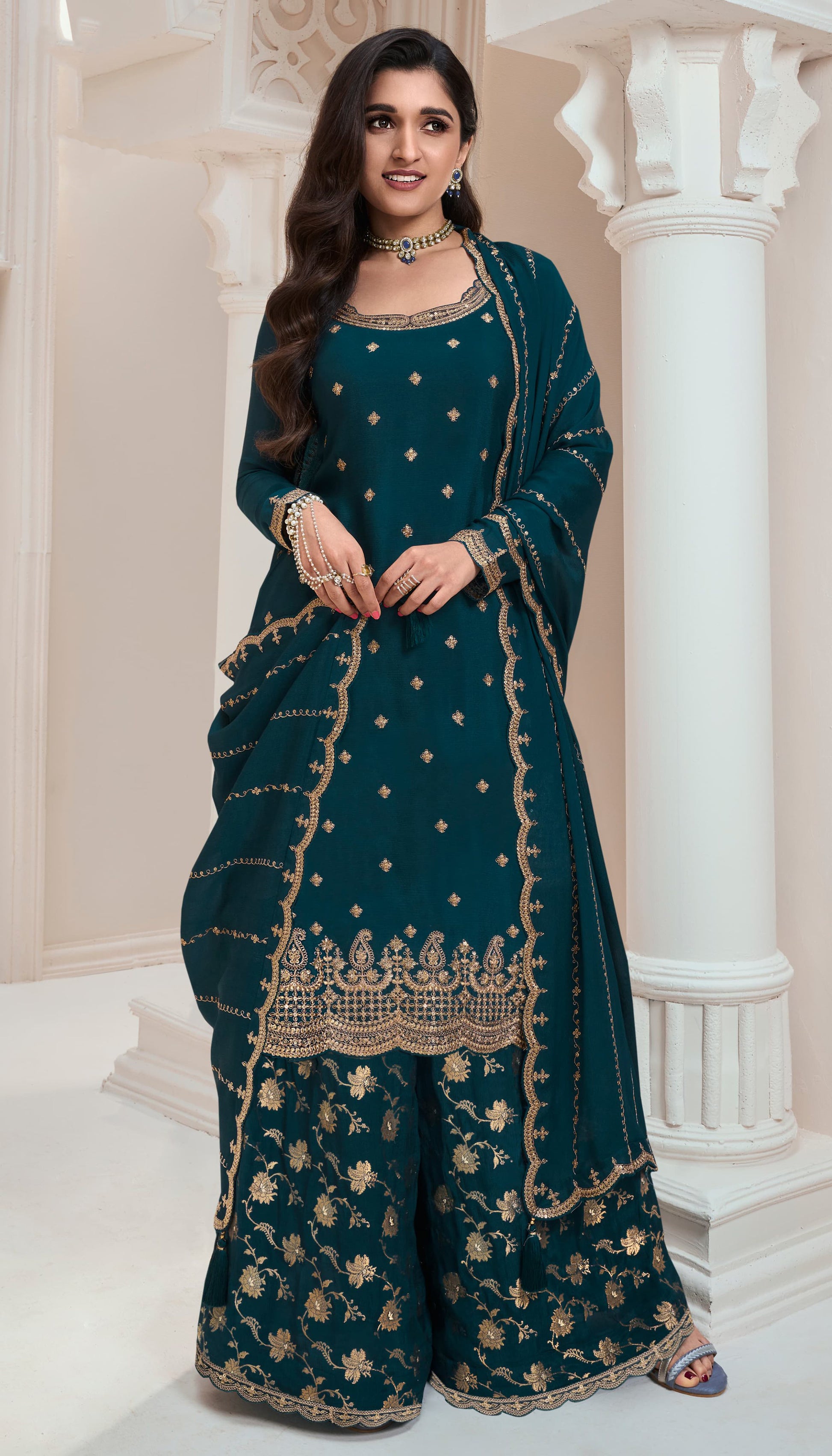 A Woman Wearing a Traditional Teal Palazzo Dress with Dupatta Featuring Embroidered