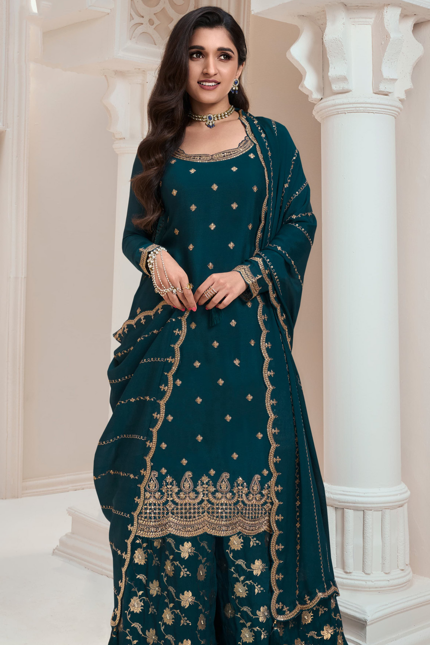 A Woman Wearing a Traditional Teal Palazzo Dress with Dupatta Featuring Embroidered