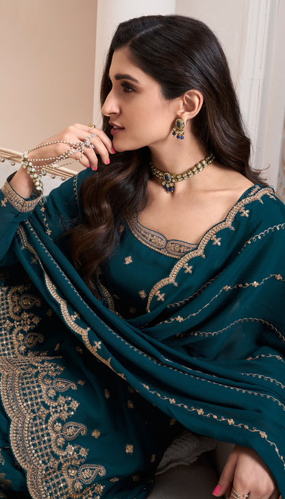 A Woman Wearing a Traditional Teal Palazzo Dress with Dupatta Featuring Embroidered