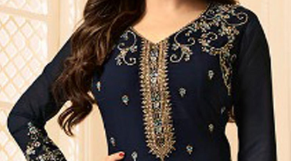A woman wearing a navy blue traditional outfit with ornate gold embroidery and embellishments on the neckline and sleeves.