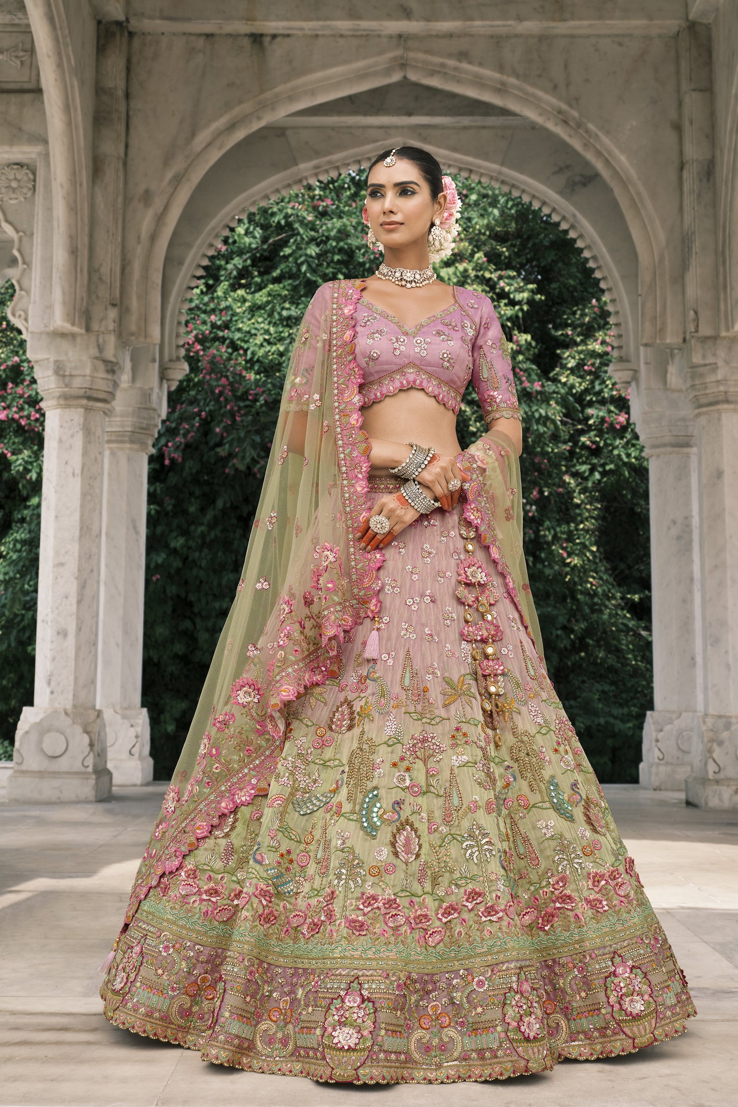 “Pastel pink and green floral embroidered designer lehenga choli with intricate zari, sequin work, and net dupatta