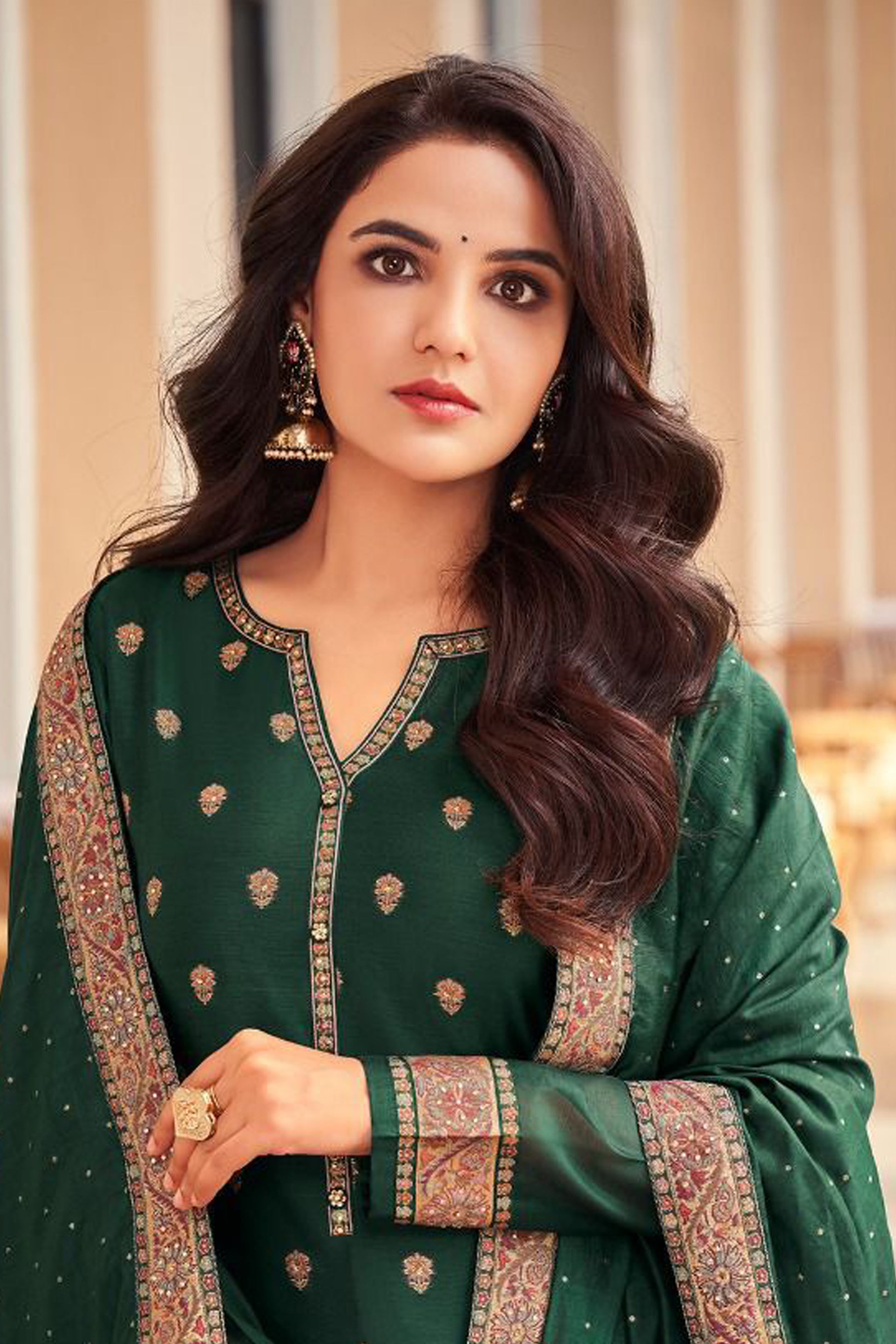 Woman wearing a green traditional outfit with intricate patterns