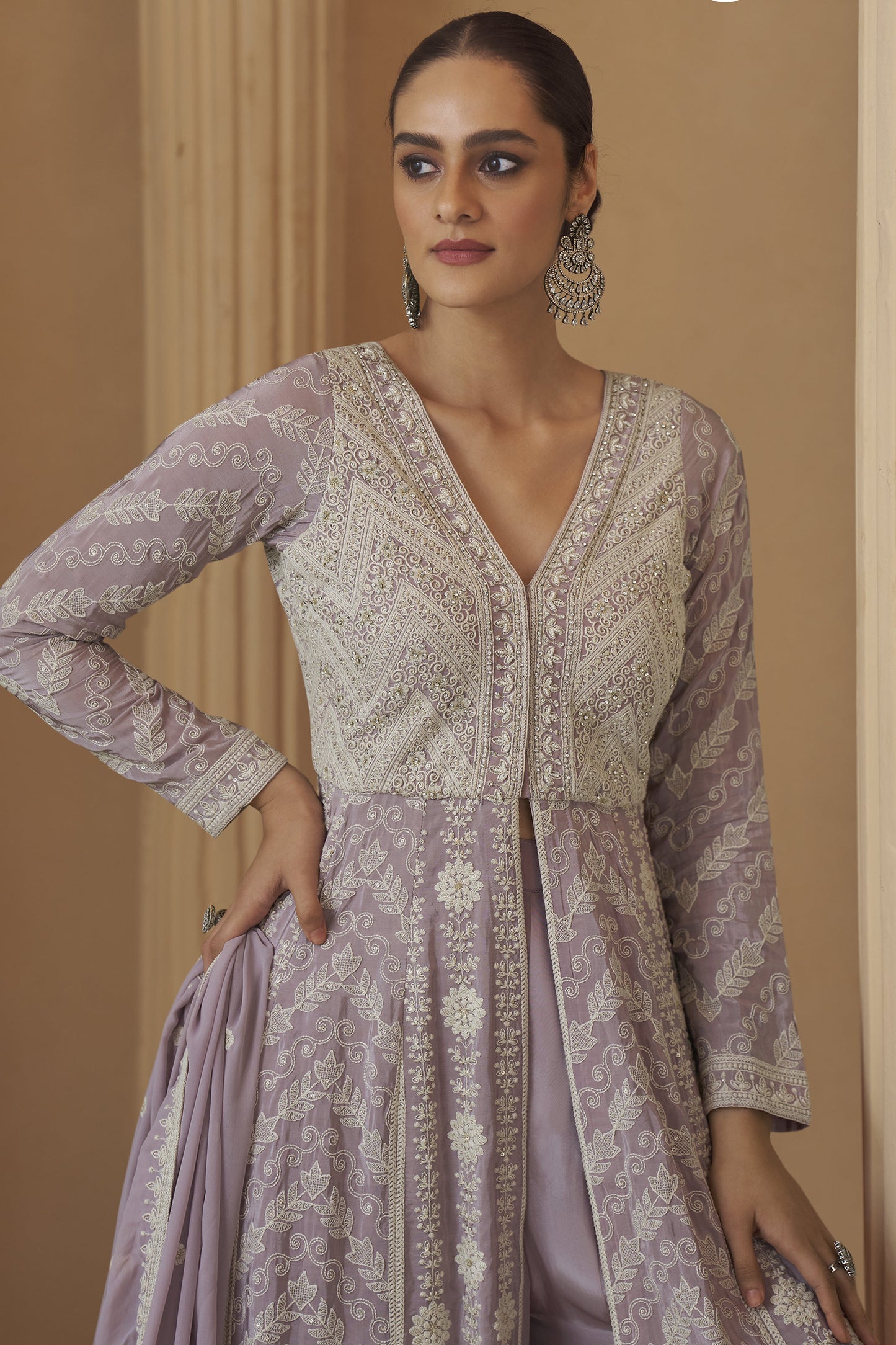 close-up of chikankari embroidered work on lavender fabric