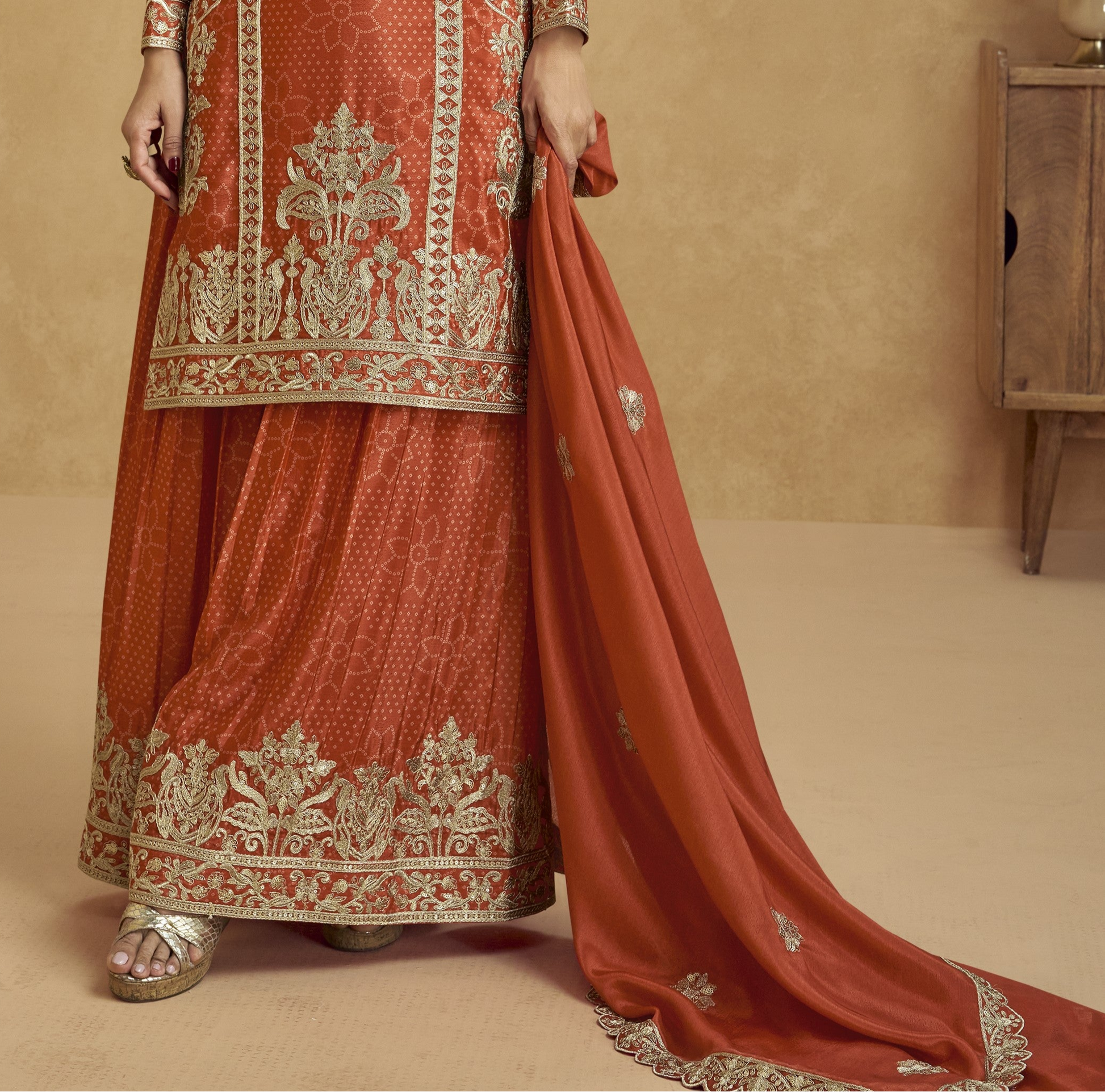 Rich dark orange outfit with bold traditional charm, ideal for festive functions, mehndi nights, and cultural celebrations.
