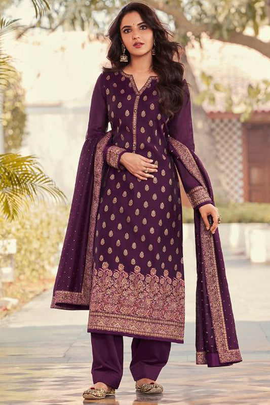 Woman wearing a purple traditional outfit with gold patterns outdoors.