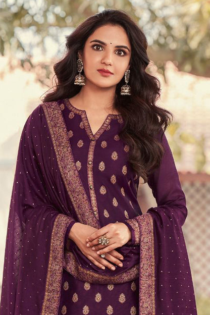 Woman wearing a purple traditional outfit with gold patterns outdoors.