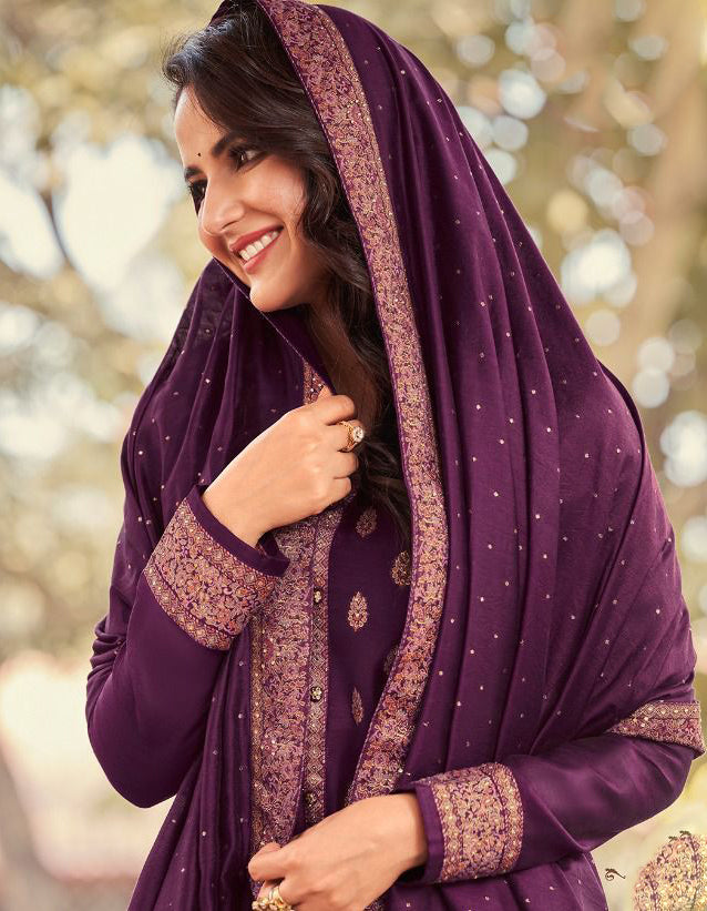Woman wearing a purple traditional outfit with gold patterns outdoors.