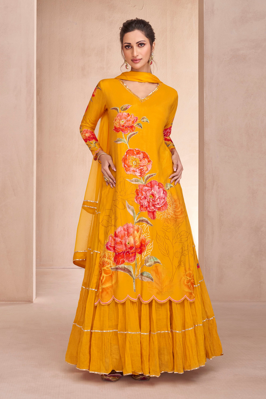 A woman wearing a yellow Indian sharara suit with floral embroidery and a dupatta.