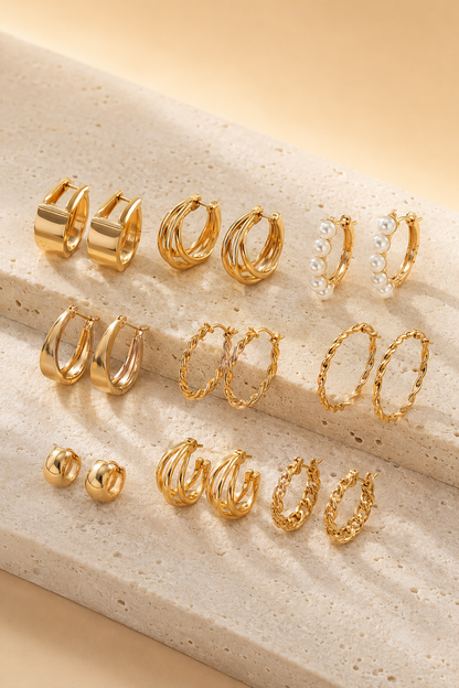 Mixed hoop earring collection arranged on dark velvet under warm light