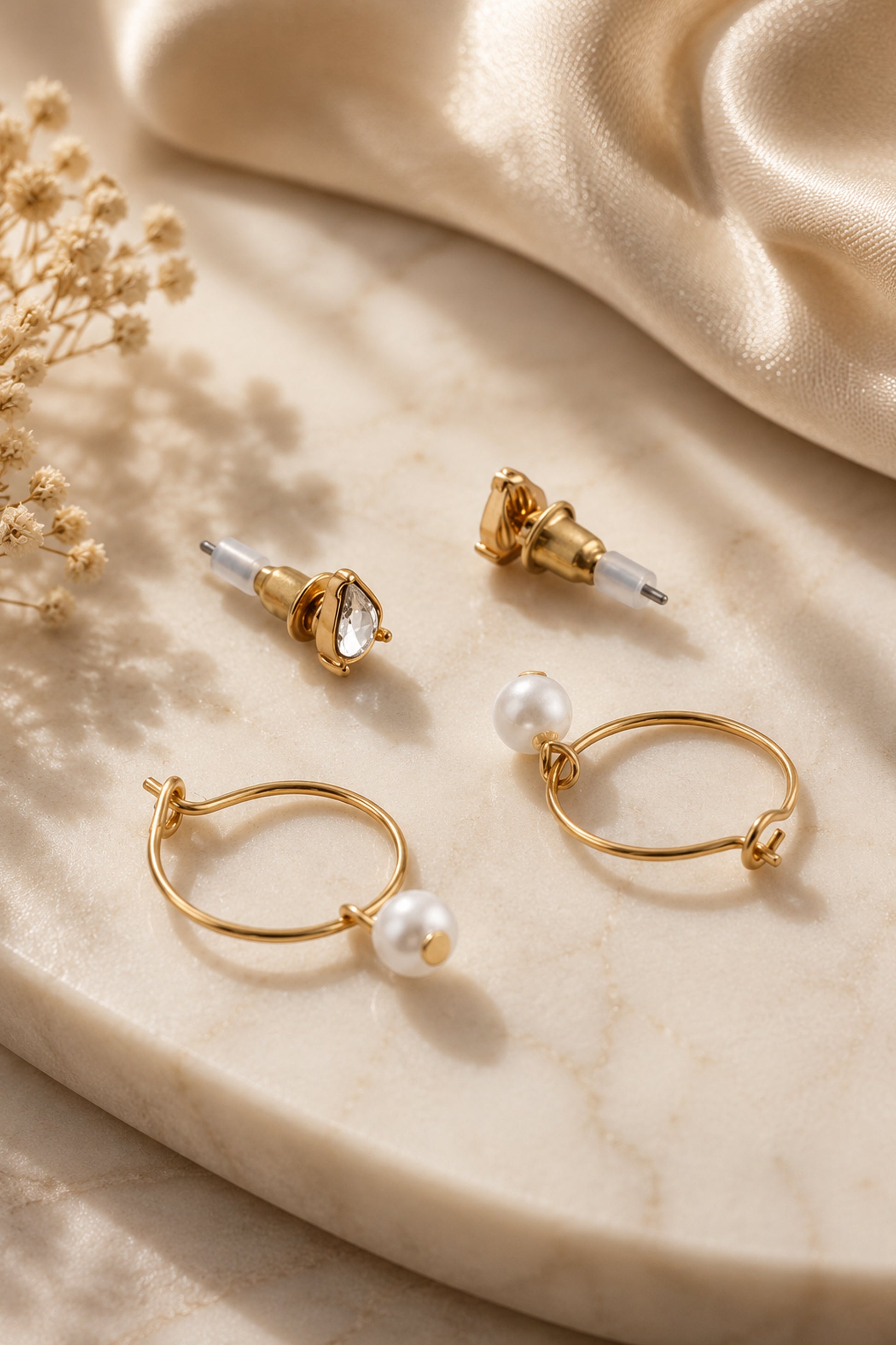 Close view of teardrop studs and pearl-drop hoop earrings