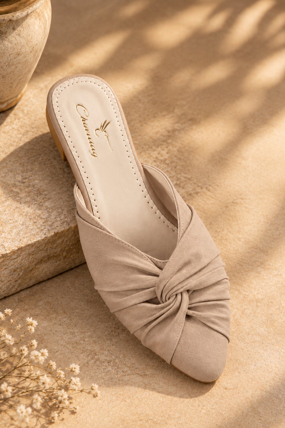 Pair of beige women’s mules with closed rounded toes