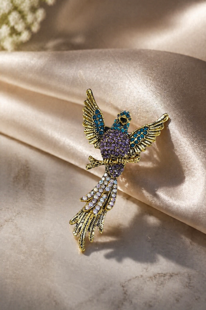 gold tone bird brooch pin with purple and blue stones