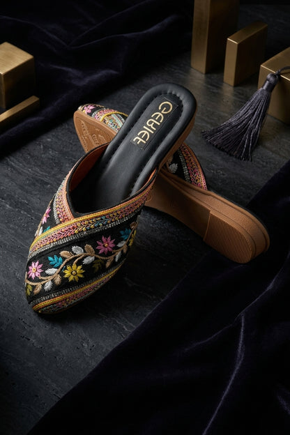 Black pointed-toe jutti mule with floral vine embroidery