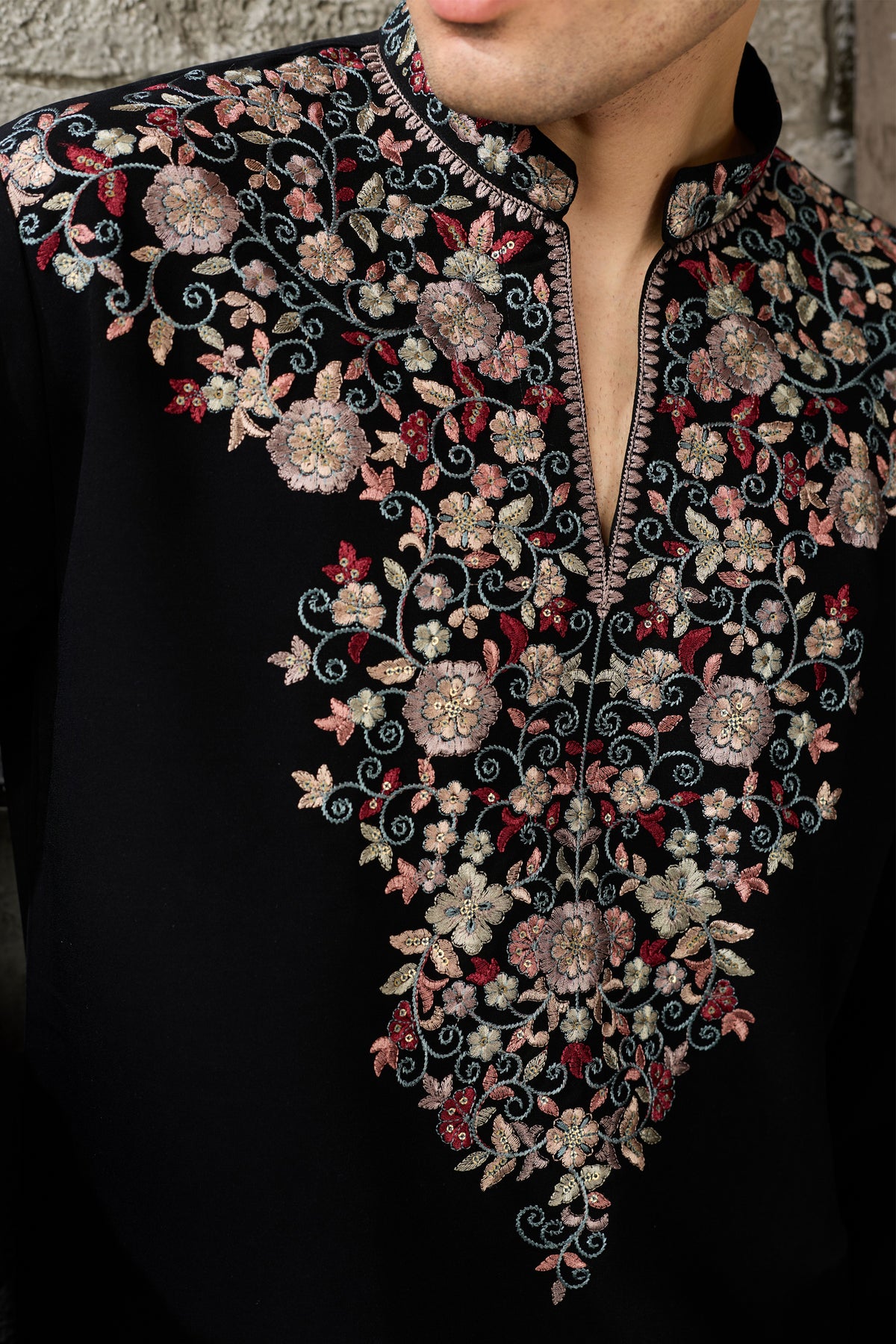 Close-up of thread embroidery on black kurta
