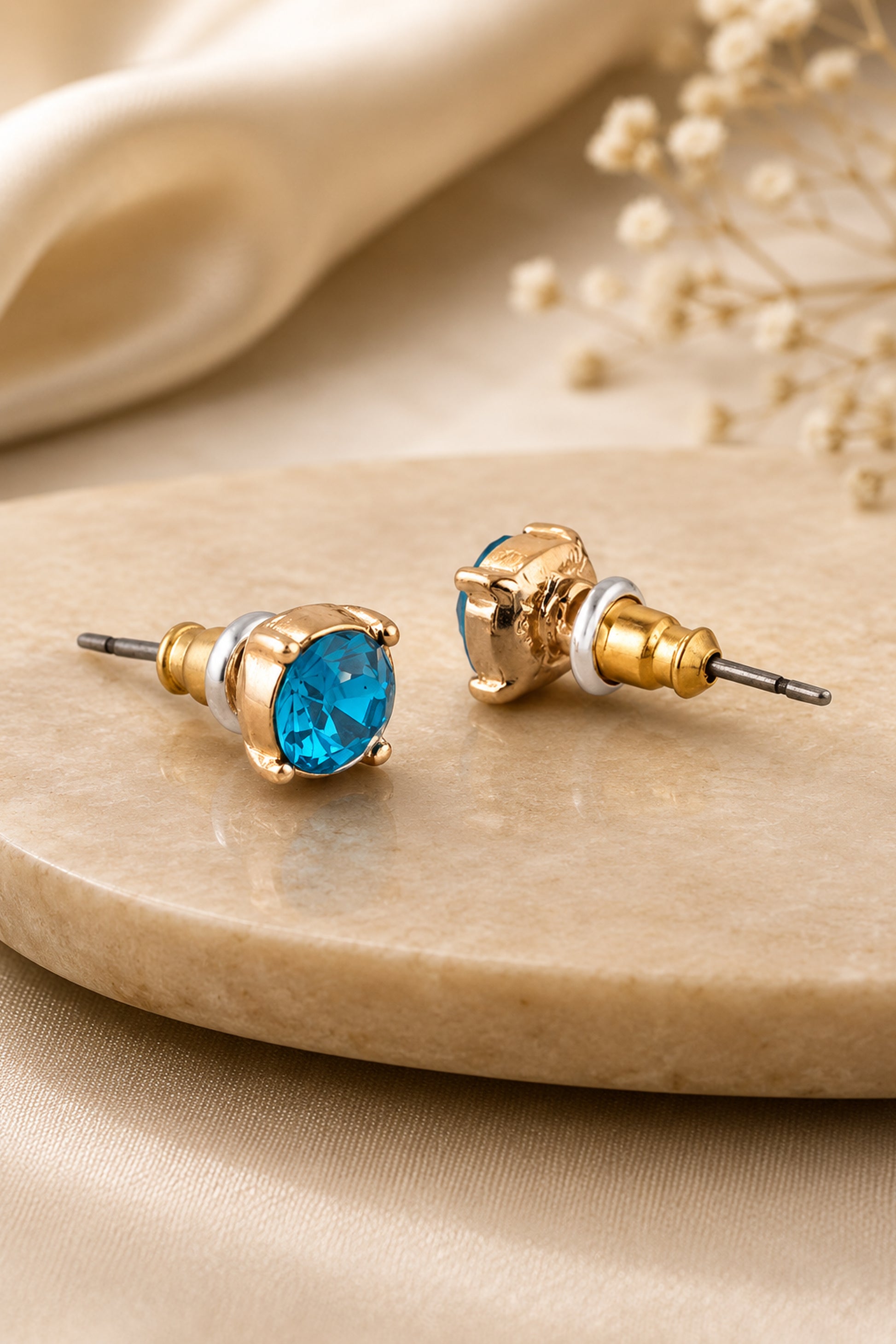 Blue faceted accent stud earrings shown in close-up