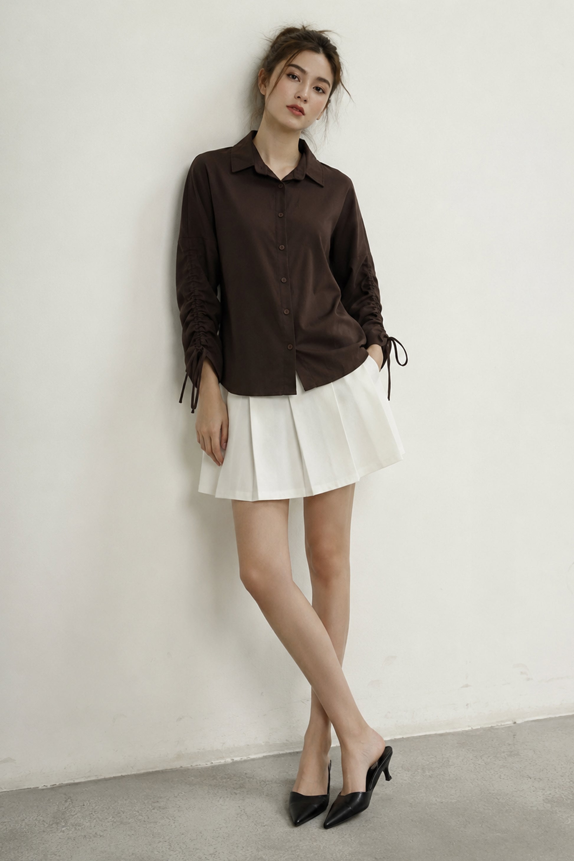 Brown shirt displaying gathered sleeves and tie details