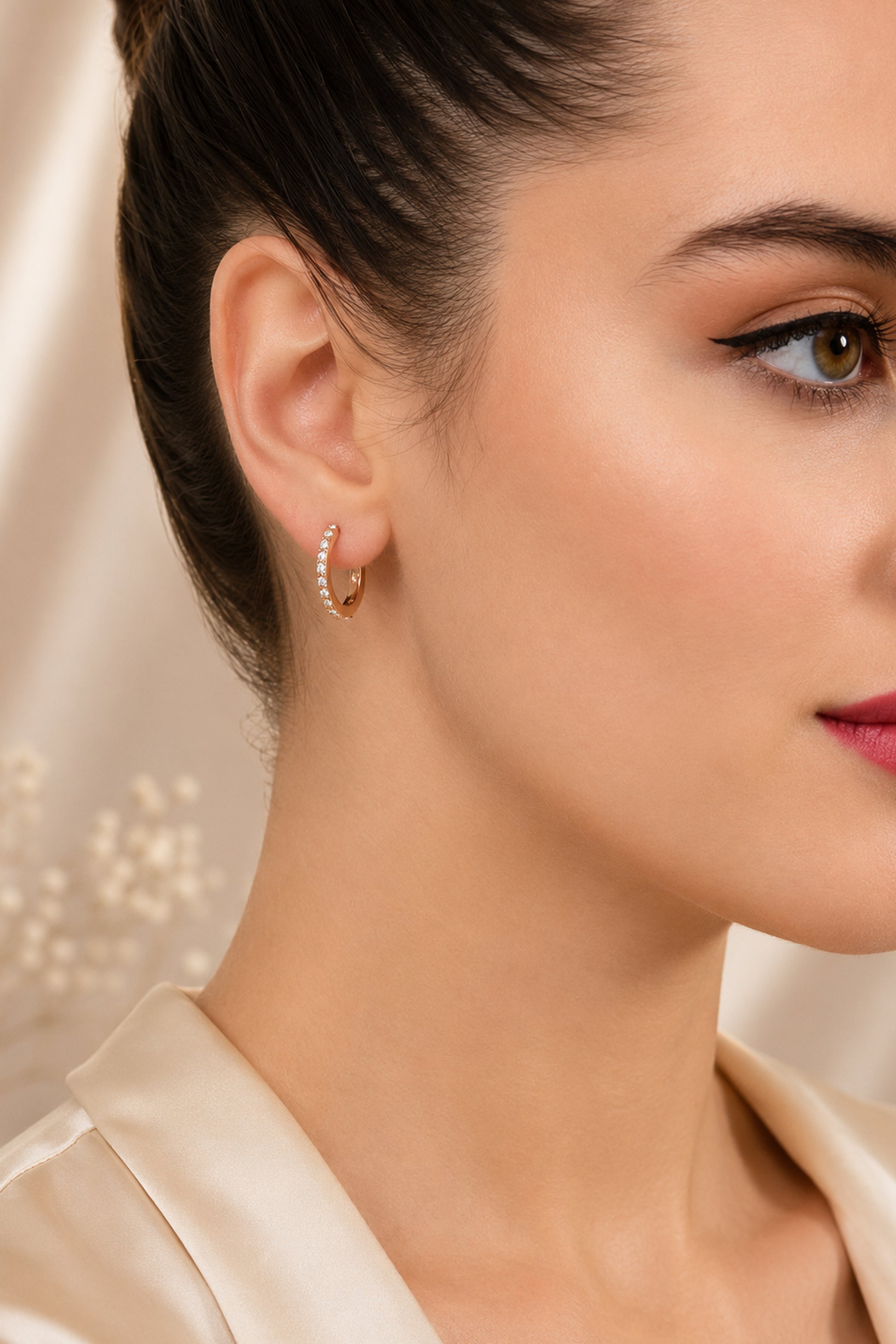 Gold-tone hoop earring with a polished drop detail