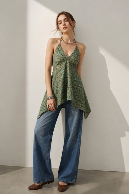 side pose green printed halter neck top with denim pants styling