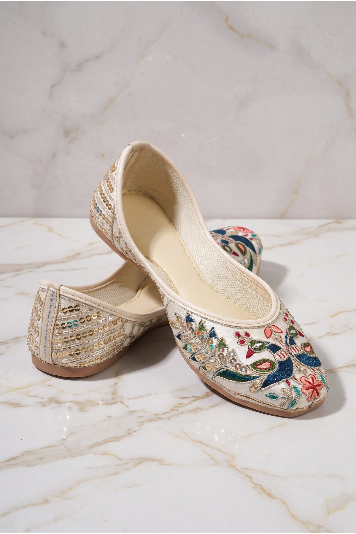 Front toe view of cream mojari featuring blue peacock and peach flowers