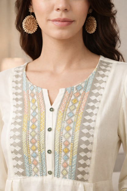 Close-up of floral embroidered detail on cotton tunic