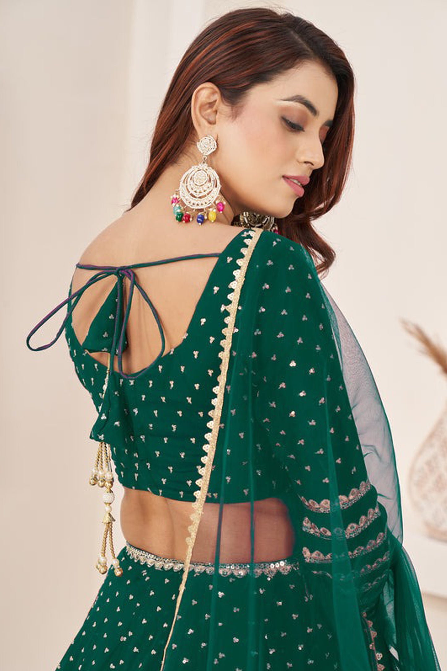 Close-up of zari work on dark green lehenga skirt
