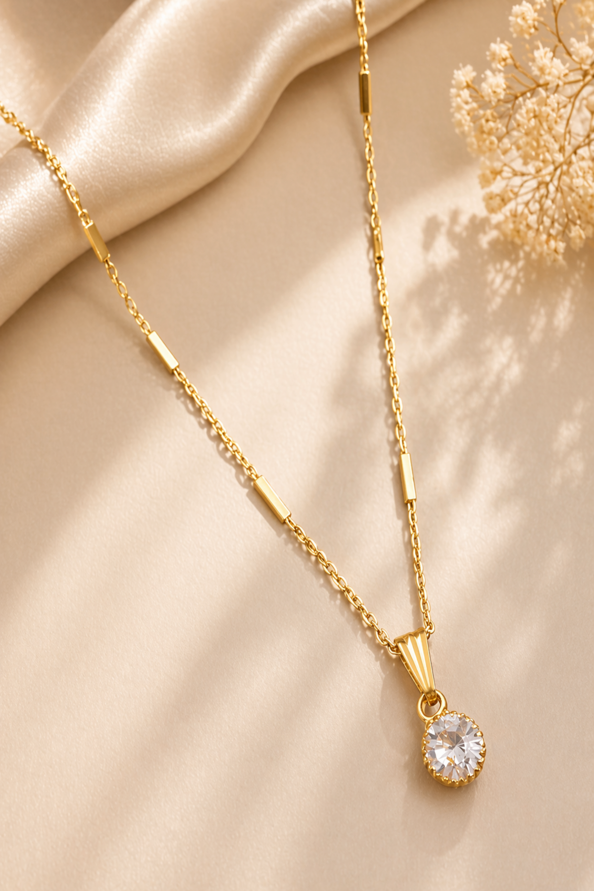 gold necklace with round crystal pendant on neck