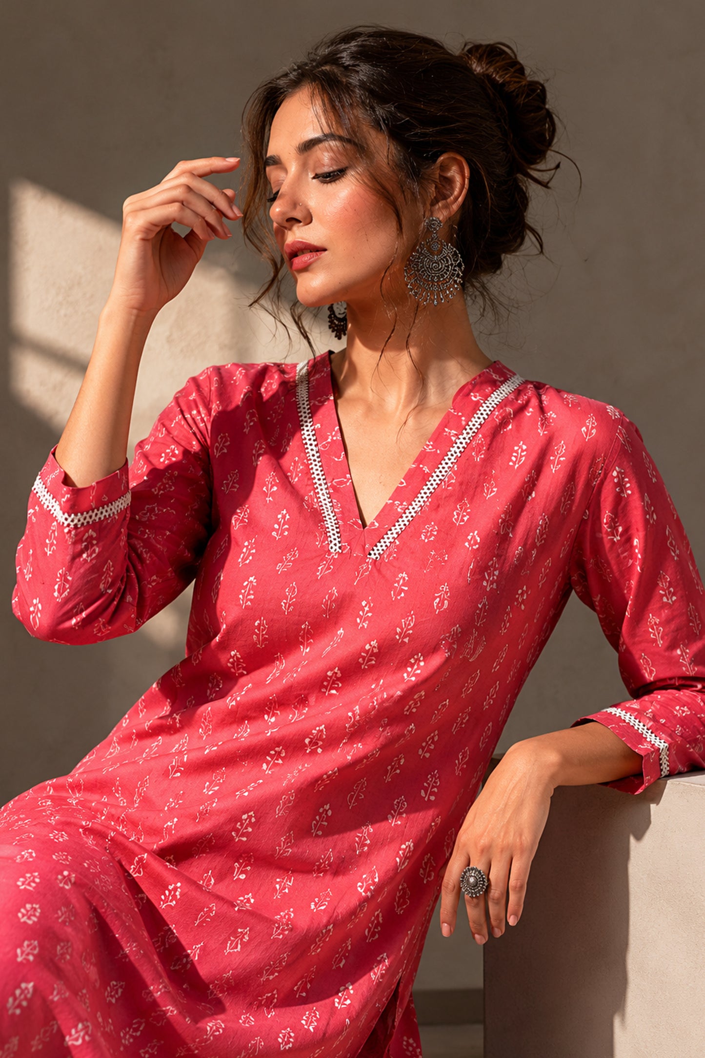 Woman wearing a pink cotton kurti with three quarter sleeves