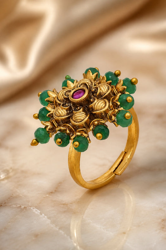 gold tone fashion ring with floral design and green accents