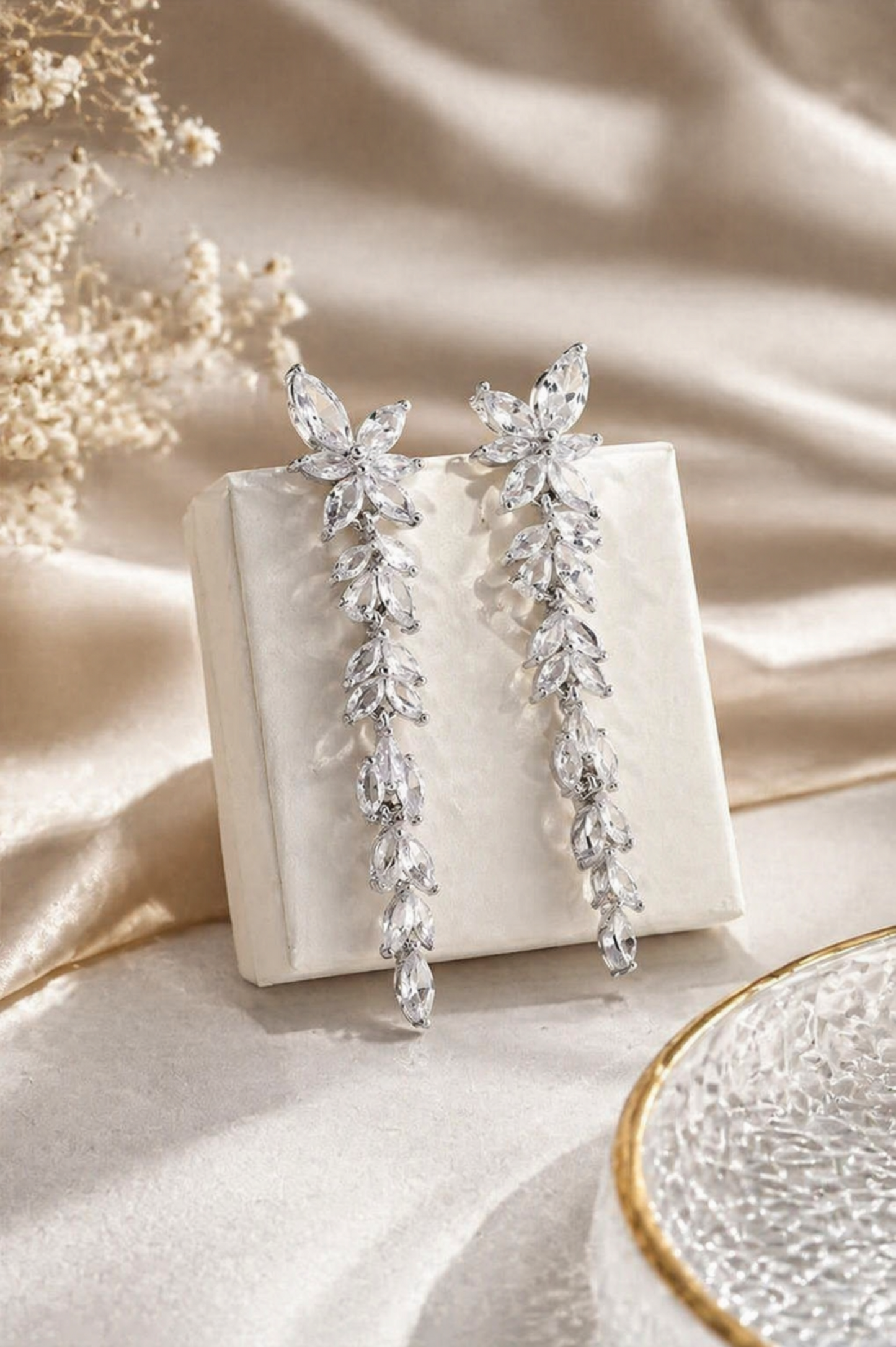 rhodium plated crystal leaf cascade earrings long drop bridal jewelry styled on neutral luxury background