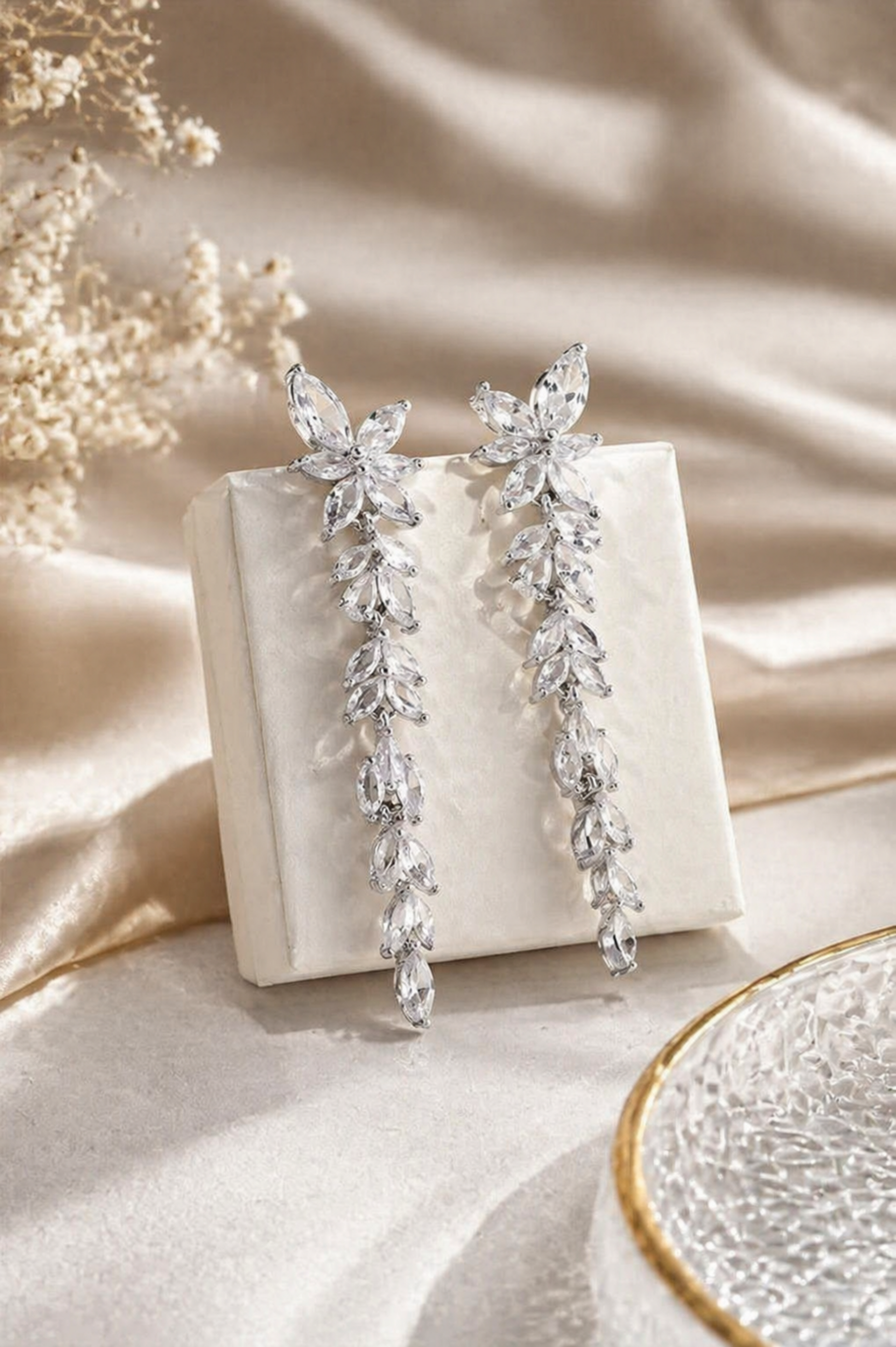 rhodium plated crystal leaf cascade earrings long drop bridal jewelry styled on neutral luxury background