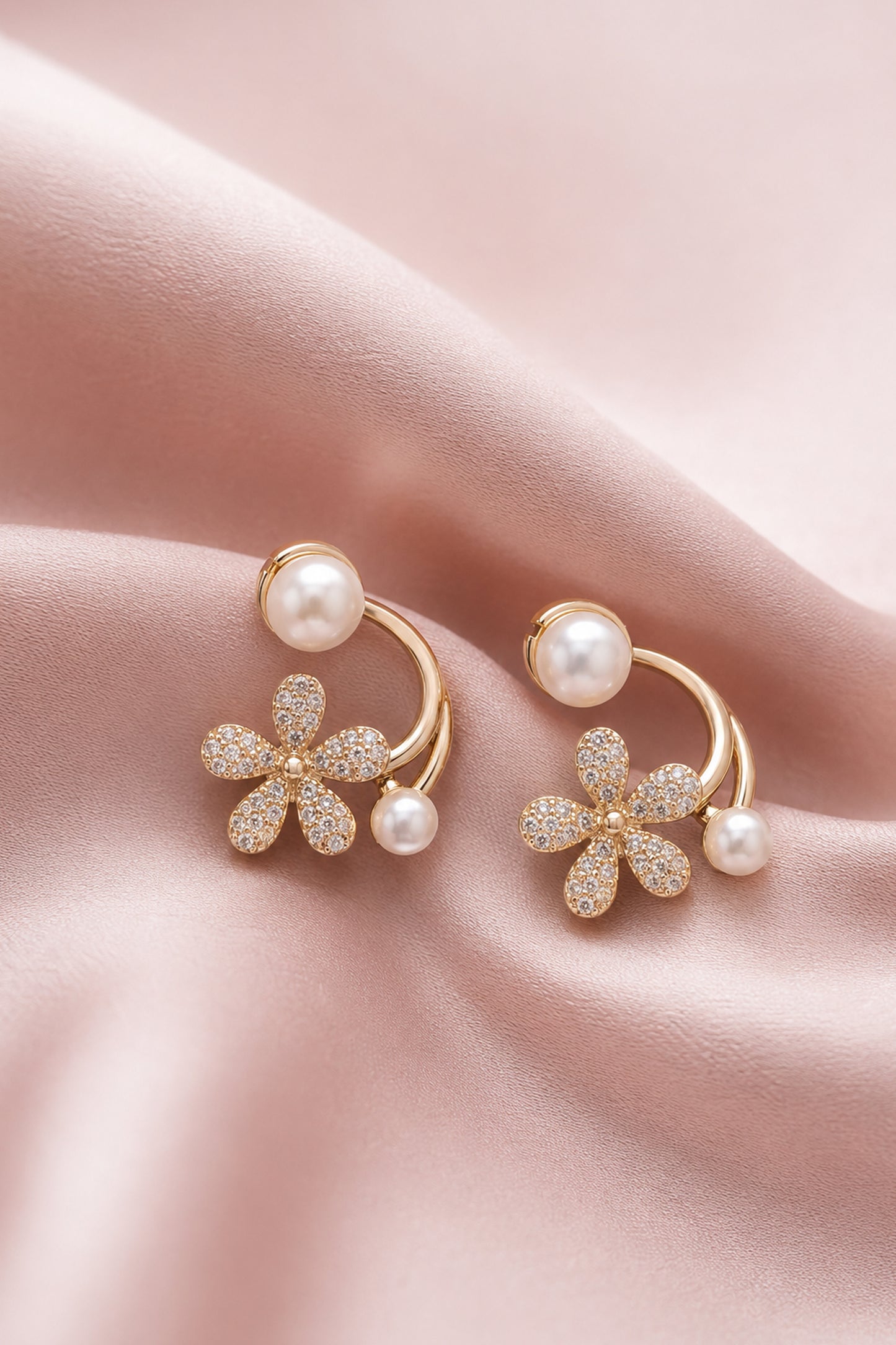 Floral earrings with clear stones and white pearl-like beads on blush fabric