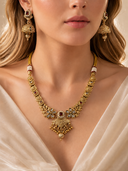 Close-up of textured necklace with red and clear stone accents
