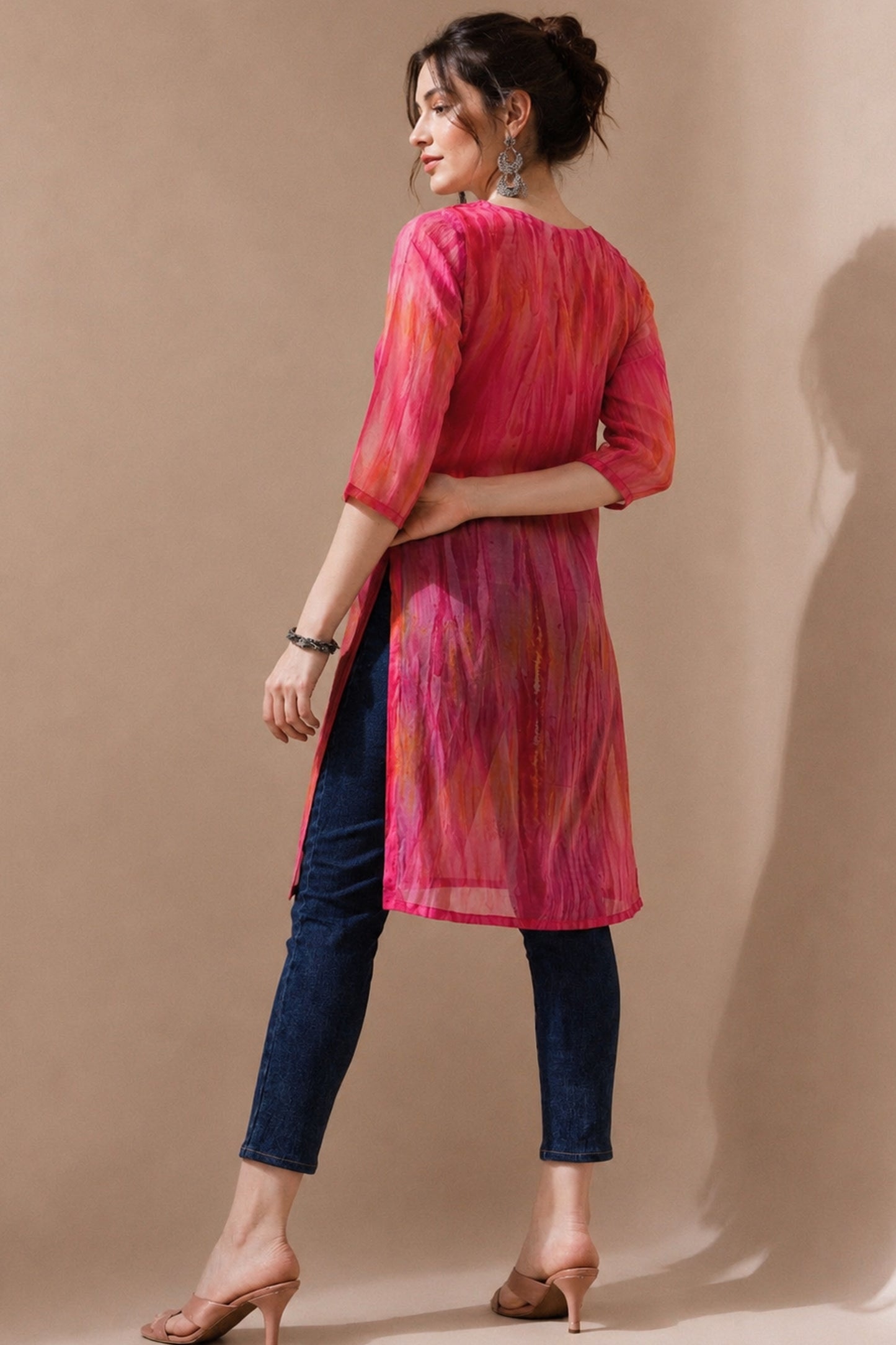 Side pose featuring pink embroidered kurti with denim styling