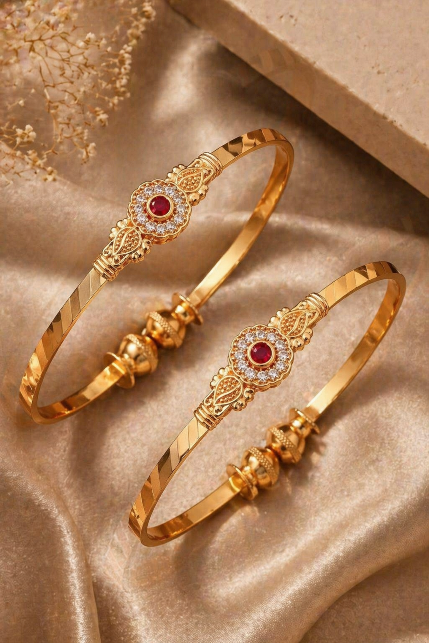 pair of polished gold bangles on satin fabric