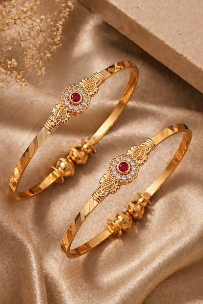 pair of polished gold bangles on satin fabric
