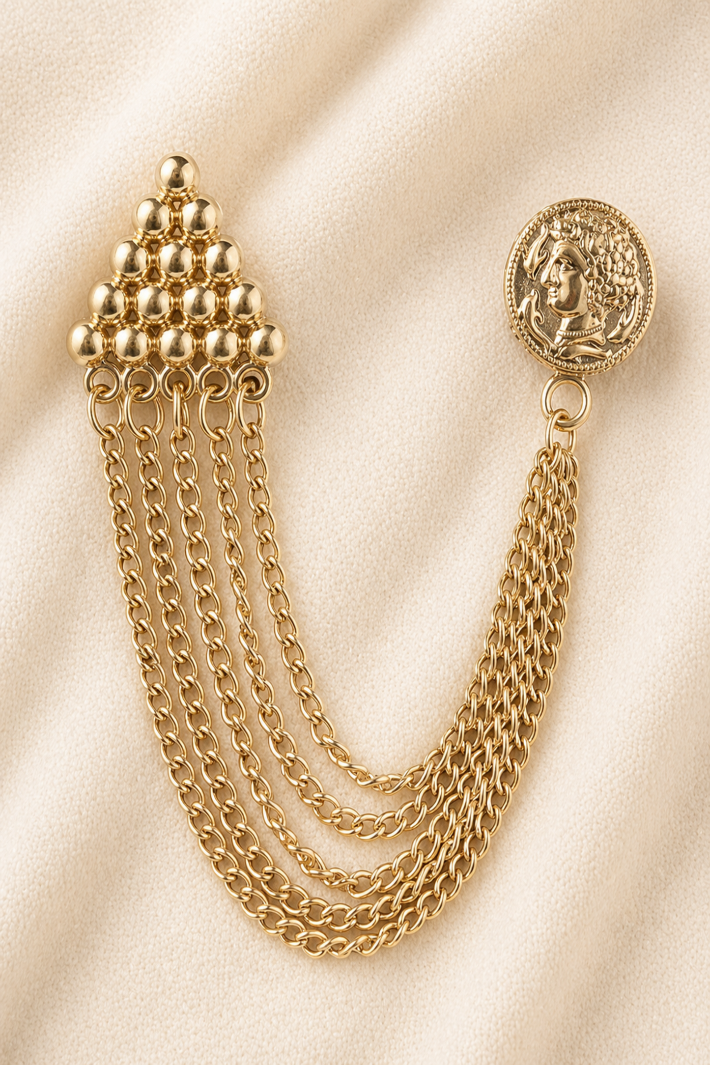 gold chain brooch with layered chains on fabric