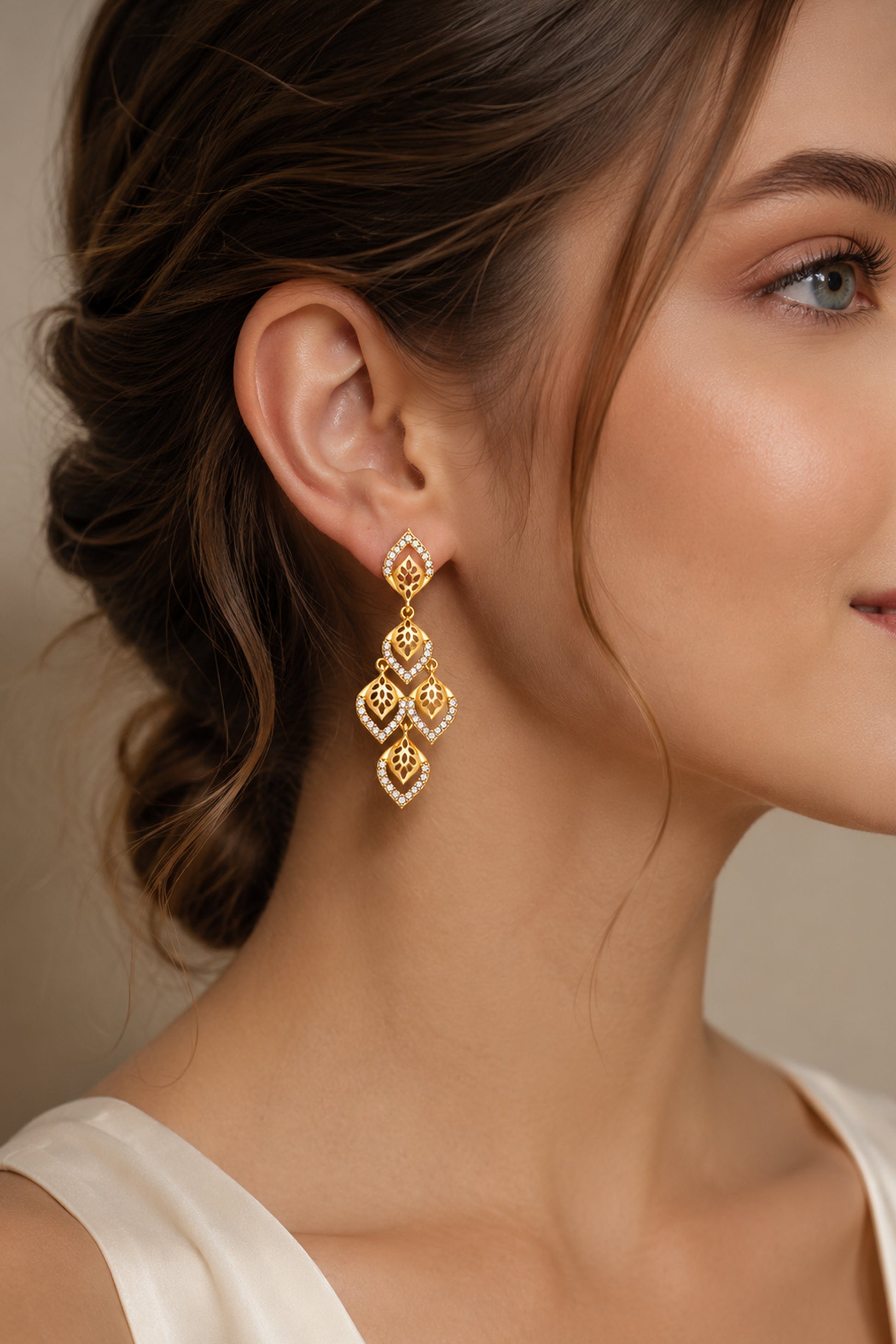 Close-up of polished gold-tone drop earrings with clear stones