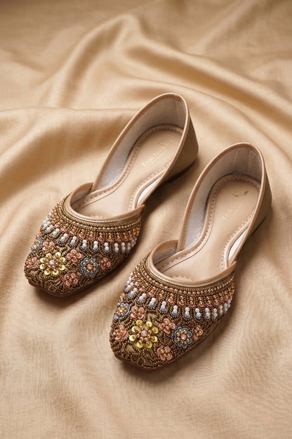 Pair of gold wedge juttis with intricate pastel floral beadwork