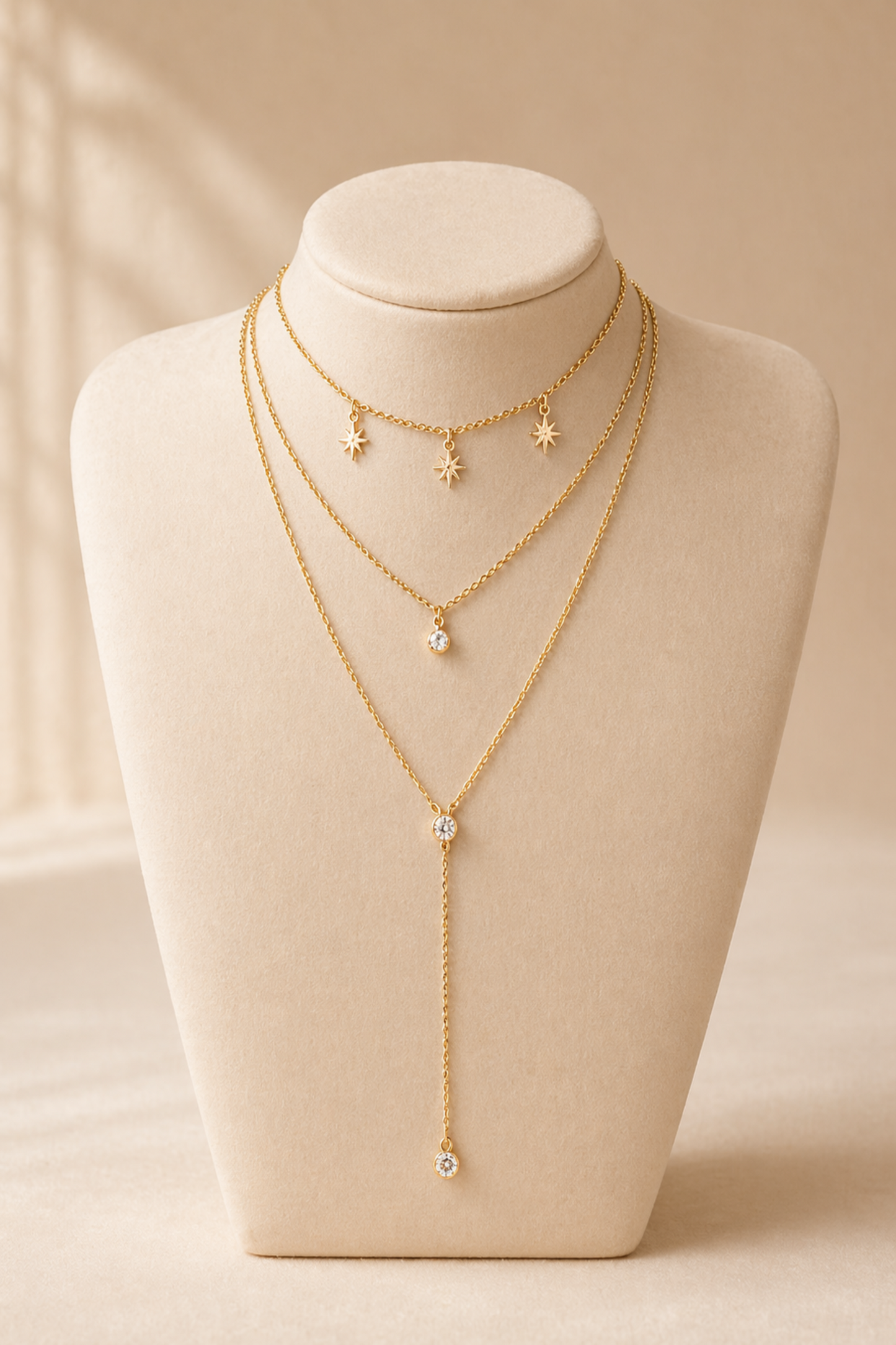 gold layered necklace with star charms and drop pendant