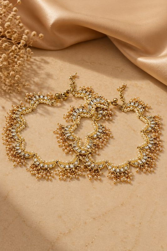 gold pearl anklet set on beige surface
